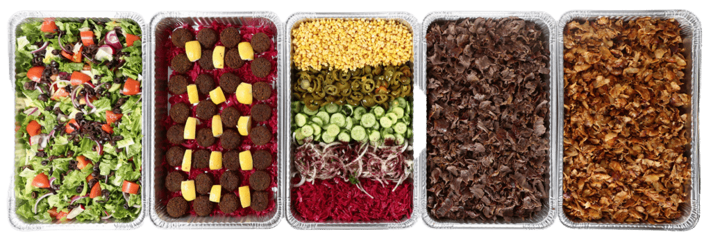 DonerG Mediterranean catering spread featuring fresh salads, crispy falafel, grains, döner meat, and signature toppings arranged in catering trays