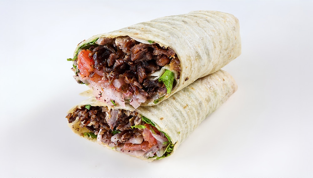 Our signature doner wrap: seasoned beef, fresh vegetables, and house-made sauces wrapped in warm lavash bread.