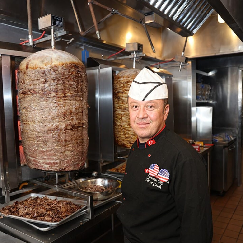 Chef with donerg vertical meat rotisserie.