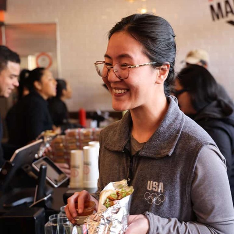 Person holding a donerg wrapped sandwich.