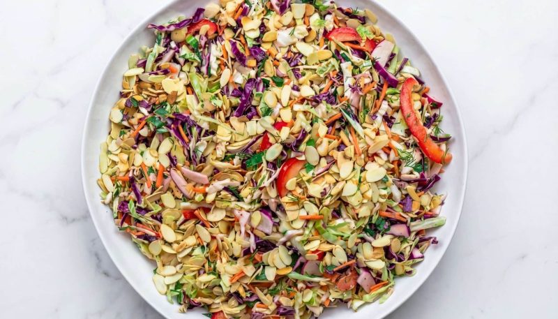 mediterranean cabbage salad with shredded cabbage, carrots, herbs, and almonds in a bowl