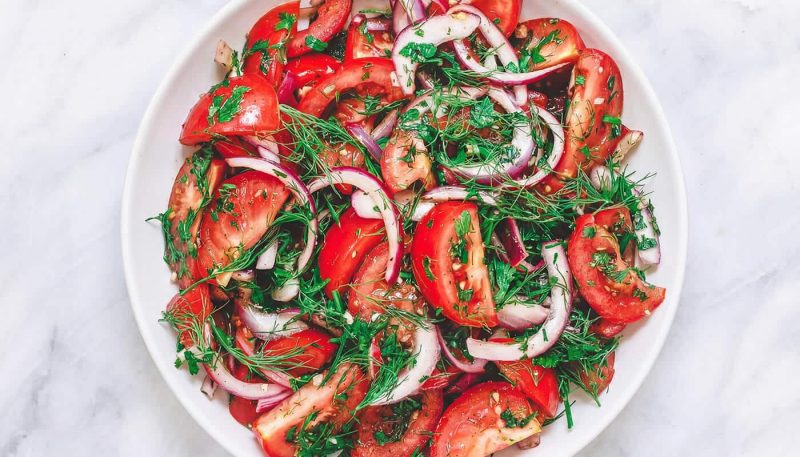 Mediterranean tomato salad with red onions, fresh herbs, and feta cheese