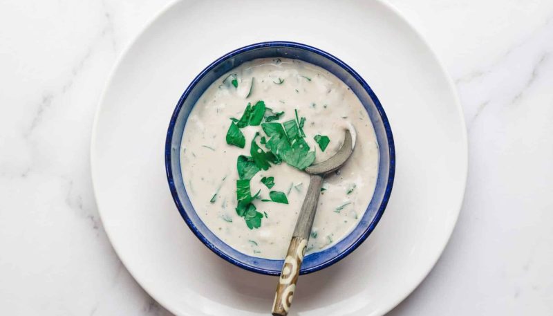 Creamy tahini sauce with fresh parsley in a bowl, served as a Turkish Mediterranean dressing